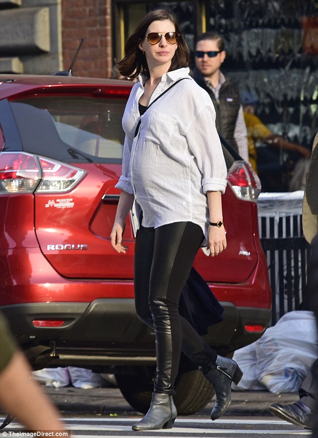 So stylish: The mother-to-be wore skintight black leather leggings and a T-shirt, layering a billowy striped collared blouse on top