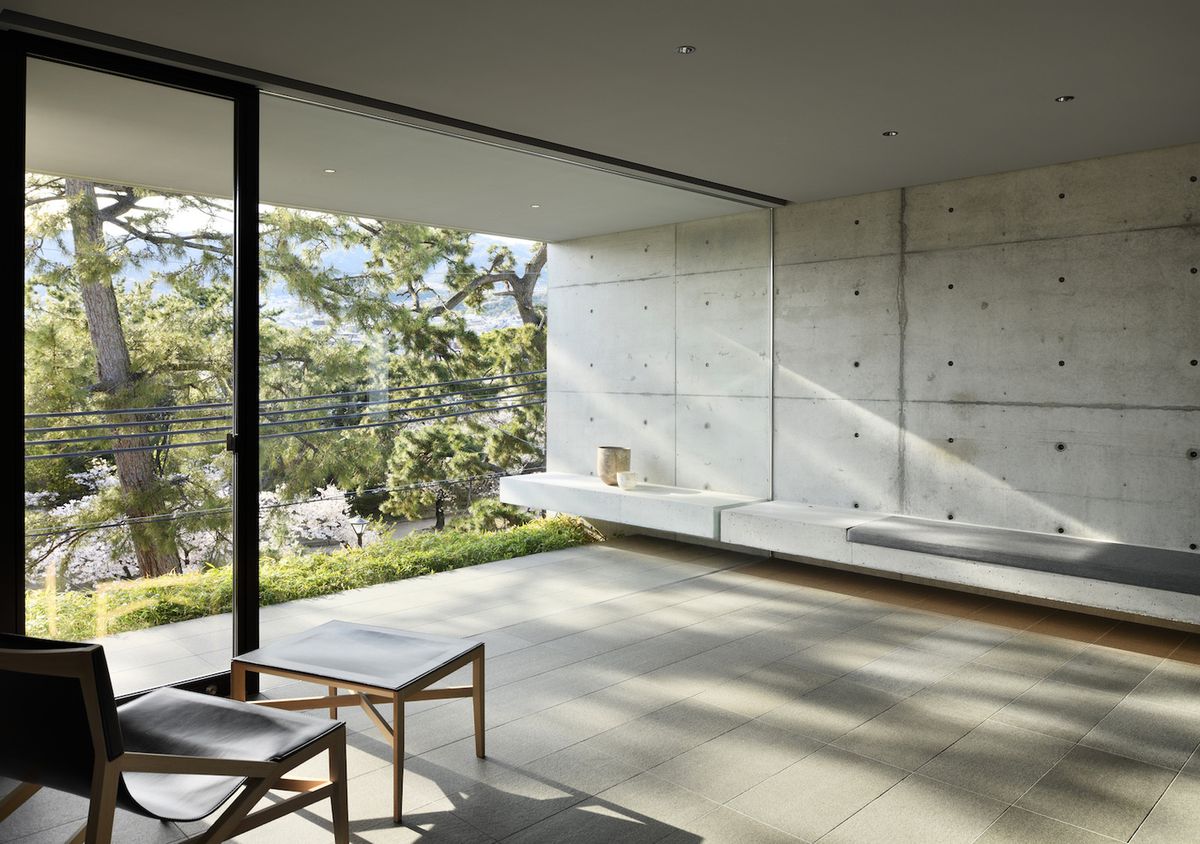 Room with concrete walls and bench, with natural light filtering in,